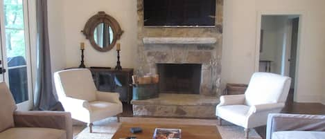 Living room with stone fireplace with gas starter.