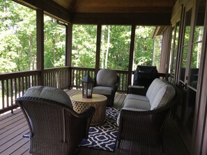 Spacious overed porch with sofa and swivel chairs.