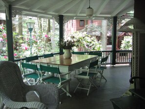 Large, gated wrap-around porch with gas grill / BBQ and outdoor dining.