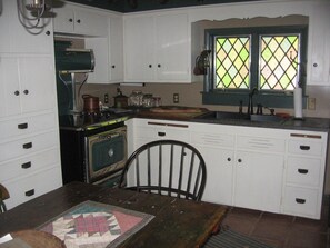 Cute eat-in kitchen stocked with dish sets, cooking utensils, pots & pans & more