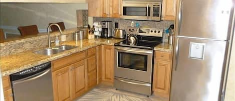 new kitchen with granite counters and stainless steel appliances