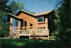 Lakeside view of house.  Manicured lawn for all your outdoor games.
