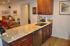 Large kitchen peninsula with slab granite open to living area