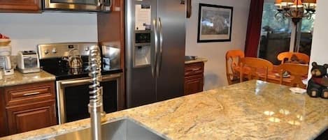 Luxurious and modern kitchen with slab granite peninsula.