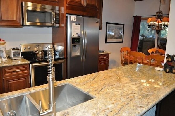 Luxurious and modern kitchen with slab granite peninsula.