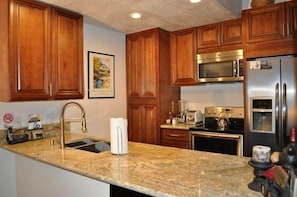 Luxurious kitchen with cinnamon glaze cabinetry, stainless steel appliances.