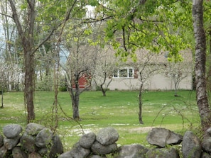 Front of cottage through the apple orchard