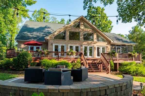 Home facing lake, path to boathouse on right, patio with fire insert in front