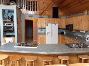 Kitchen w/ eating island.  Large food prep area. UPDATE stainless refrigerator