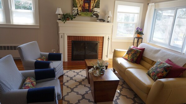 Living room with wood burning fireplace. Opposite wall is flatscreen TV.