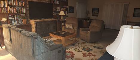 Living room w/ 3 sofas, 2 recliners and (1) futon; 65" TV; gas log fire
