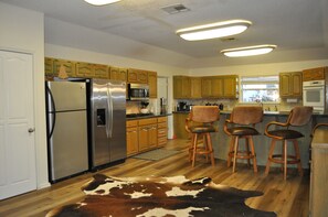 Kitchen with 2 refrigerators, 2 stoves and double ovens. 