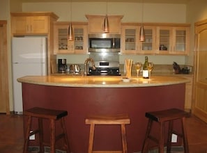 Well stocked kitchen with granite counter tops.