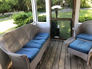 Screened in front porch with grill, dining table and sitting area