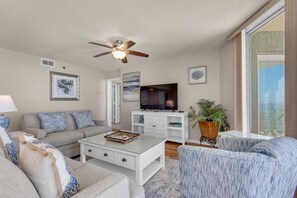 Sofa with loveseat and swivel accent chair.  Large flat screen tv in living room