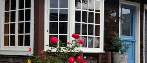 Cozy Nantucket style cottage with shingle siding, bay window and dutch doors.