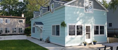 Large patio and walkway, front door and side door access to the yard.