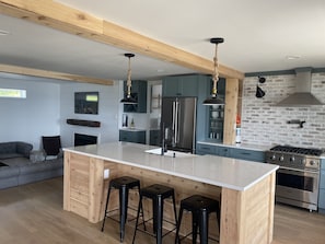 Kitchen with expansive island. All standard appliances plus a beverage fridge.