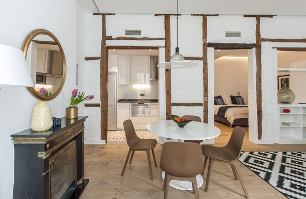 Dining area with kitchen and bedroom in the background.
