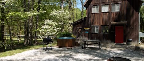 Cabin AB outside parking area with hot tub and fire pit.