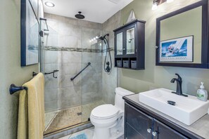 Bathroom has a glass enclosed shower with rain fall shower 