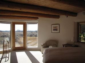 Downstairs bedroom, rounded walls, queen bed, large windows with mountain views