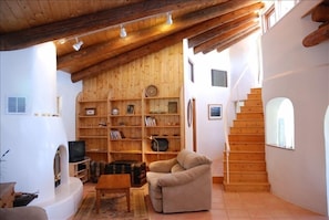 A warm, cozy woodburning fireplace in the spacious living room, firewood provide