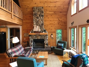 Great room with stone fireplace. Kitchen and dining areas are to the left