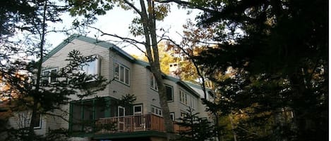 Quiet wooded area in back, sunny lawn out front.  Note screened in porch & deck.