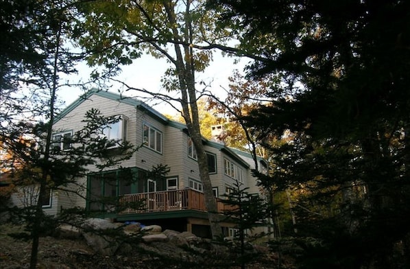 Quiet wooded area in back, sunny lawn out front. Note screened in porch & deck.