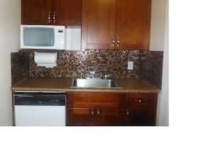 New cabinets with glass tile back splash behind the sink area
