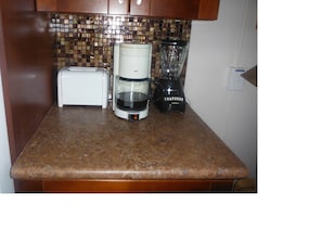 New cabinets with glass tile back splash, toaster, blender, and coffee maker