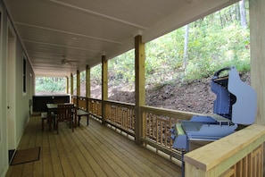 Back porch with gas grill, dining table, and hot tub.