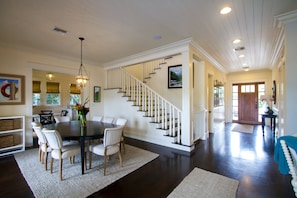 The view of the front door, stair case, dining room and kitchen in the back