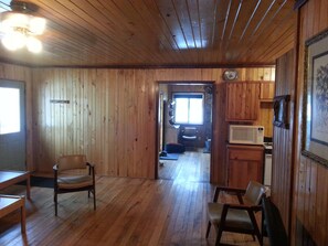 View through living room, front door, kitchen, and into wood room.
