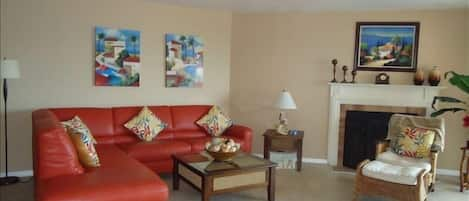 Living room w/ wood burning fireplace, 52" TV, opens to balcony and dining area.