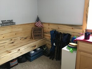 Entry way with toys, yard games, chairs, lights, shoe racks, etc