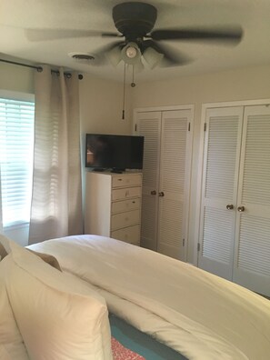 King bedroom with flatscreen television, chest of drawers and double closet. 