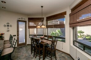 Dining area with 6 seats at table and additional 5 at bar counter. 