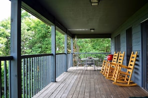 View of the porch looking right; electric grill, dining table and rockers.