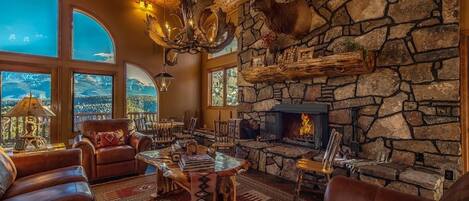 Great Room with wood ceiling, log accents, slate floors, and Pikes Peak view.