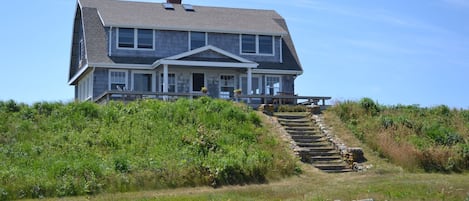 Ocean side view of house with deck and steps to path to private beach