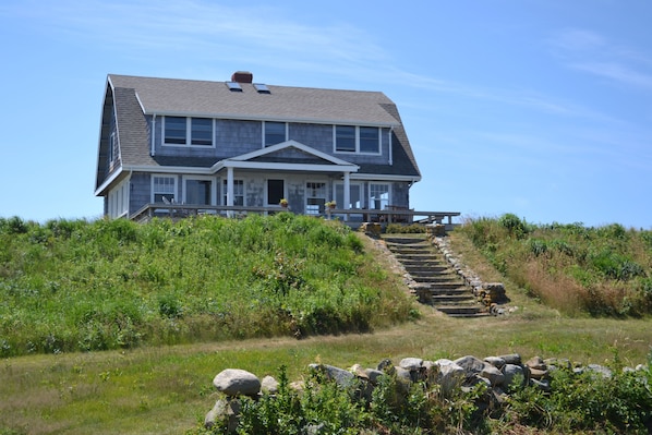 Ocean side view of house with deck and steps to path to private beach