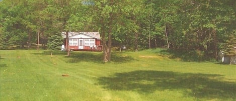 View of cabin from lake. Large gently sloping park like yard. Sand beach.