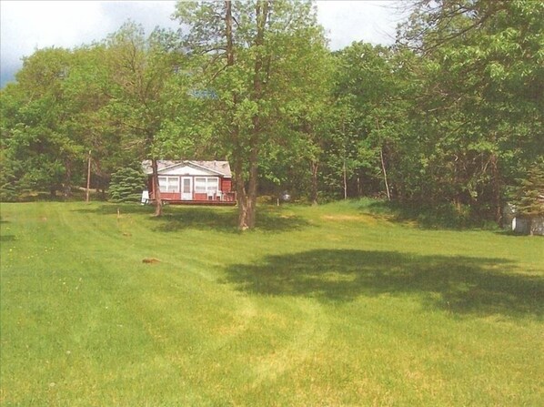 View of cabin from lake. Large gently sloping park like yard. Sand beach.