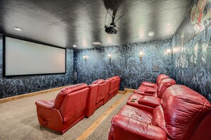 Private home theater room with plush seating and a large projection screen, ideal for movie nights and entertainment with family and friends.