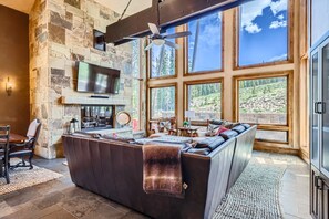 Bright and airy living room with expansive windows offering breathtaking mountain views, providing a perfect setting for relaxation and entertainment.