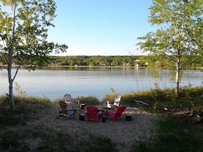 Firepit ring with grill plate in the center of Adirondack chairs