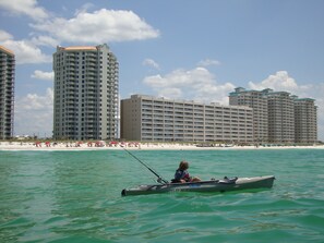 Kayak fishing off Navarre Beach; Beach Colony East Resort in the background.