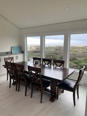 Dining area with picture windows of dunes and ocean. Sunset views for dinner.